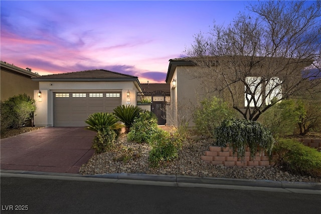 view of front of house featuring a garage, driveway, and stucco siding