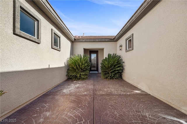 doorway to property featuring a patio and stucco siding