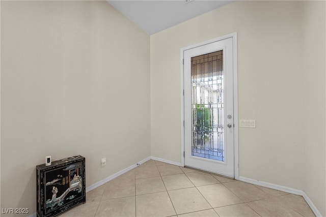 doorway featuring light tile patterned floors and baseboards