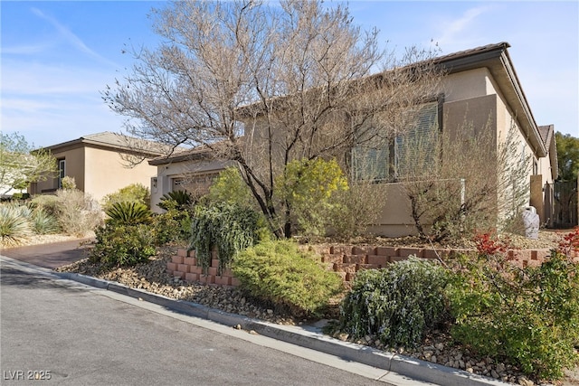 view of front of home with a garage and stucco siding