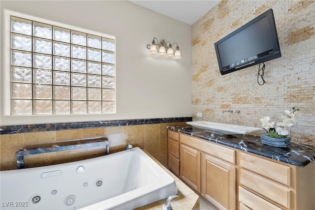 full bath featuring vanity and a tub with jets