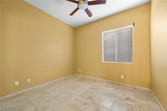 spare room featuring ceiling fan and baseboards