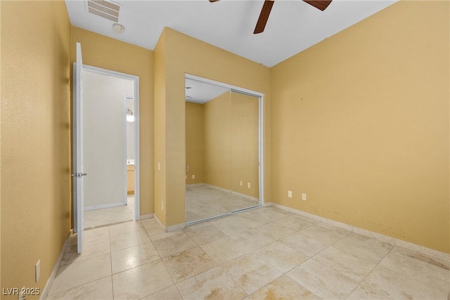 unfurnished bedroom with a closet, visible vents, a ceiling fan, baseboards, and tile patterned floors