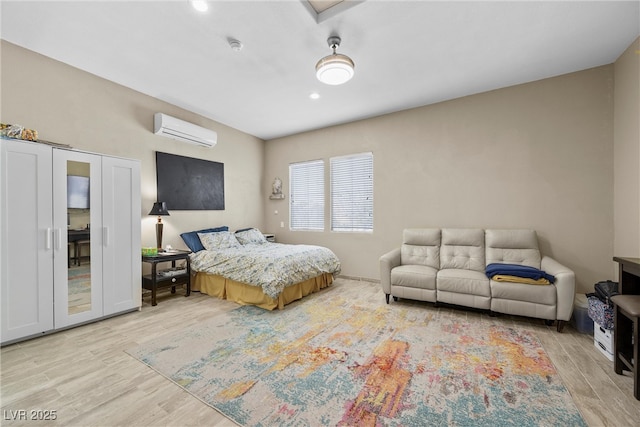 bedroom with a wall mounted air conditioner and wood finished floors