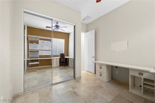 unfurnished bedroom with a ceiling fan, visible vents, a closet, and built in study area