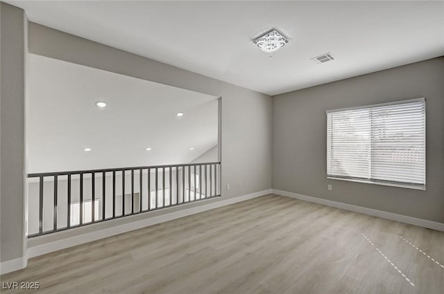 spare room with baseboards, visible vents, wood finished floors, and recessed lighting