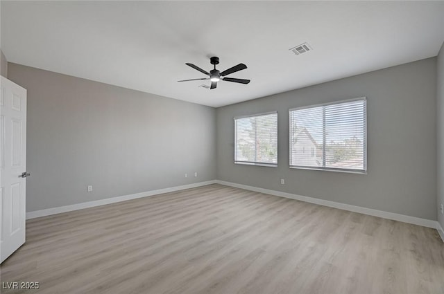 unfurnished room with ceiling fan, light wood-style flooring, visible vents, and baseboards