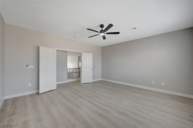 unfurnished bedroom featuring light wood-style floors, a ceiling fan, visible vents, and baseboards