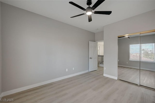 unfurnished bedroom with a ceiling fan, a closet, light wood-style flooring, and baseboards