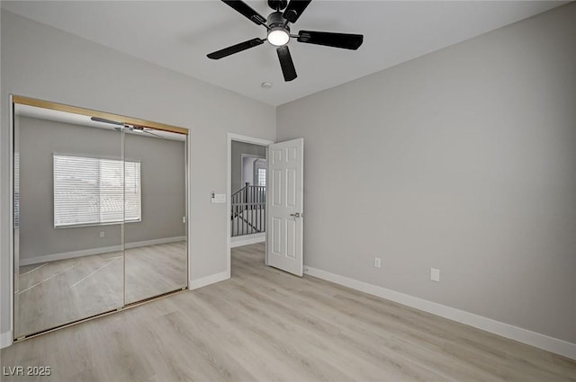 unfurnished bedroom with a ceiling fan, a closet, baseboards, and wood finished floors