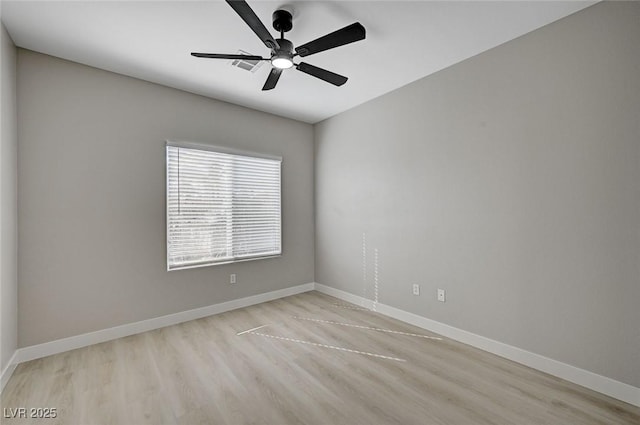 unfurnished room with ceiling fan, wood finished floors, and baseboards