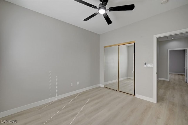 unfurnished bedroom with a ceiling fan, light wood-type flooring, a closet, and baseboards