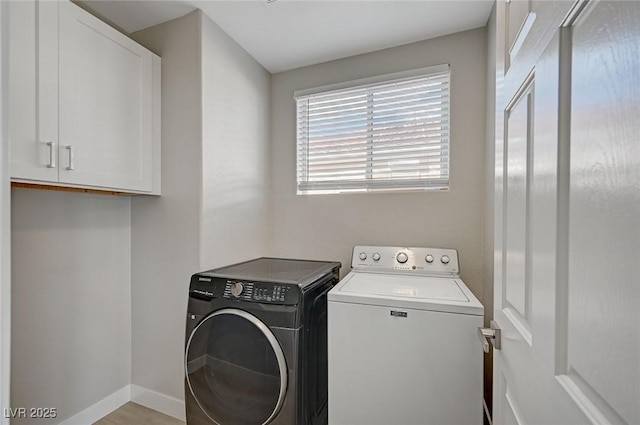 clothes washing area with cabinet space, washer and clothes dryer, and baseboards