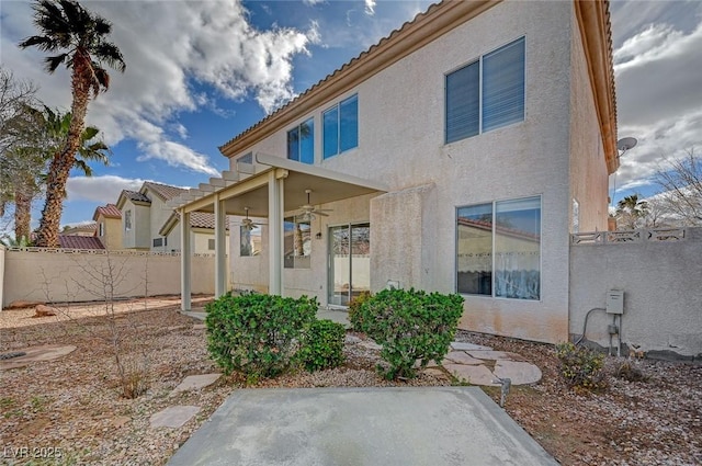 rear view of house with a patio, a fenced backyard, a ceiling fan, a tiled roof, and stucco siding