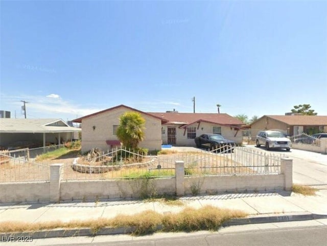 ranch-style house featuring a fenced front yard, a residential view, and concrete driveway