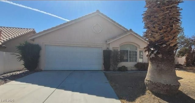 view of front facade featuring concrete driveway, an attached garage, and stucco siding