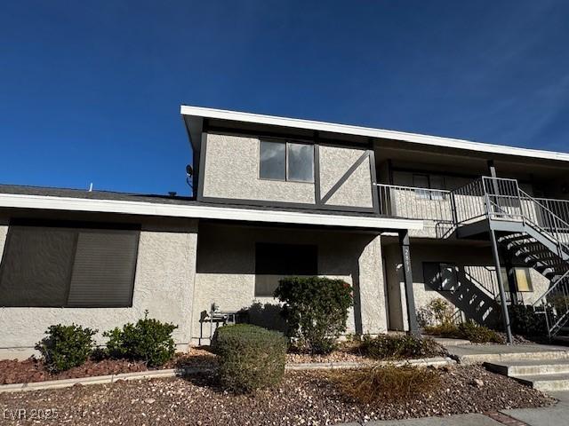 view of front facade featuring stairway and stucco siding