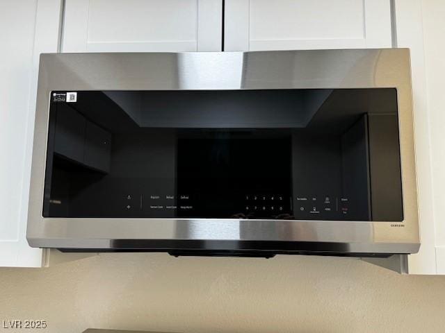 interior details with stainless steel microwave and white cabinets