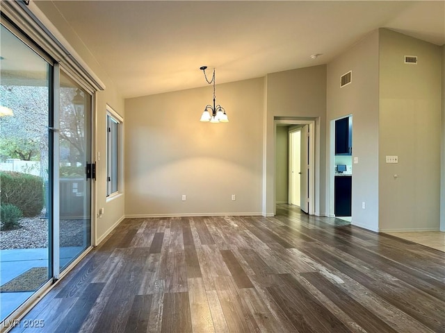 unfurnished room with lofted ceiling, dark wood-style floors, visible vents, and a chandelier