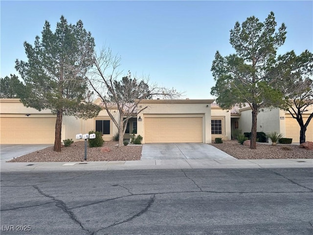 view of front facade with driveway, an attached garage, and stucco siding