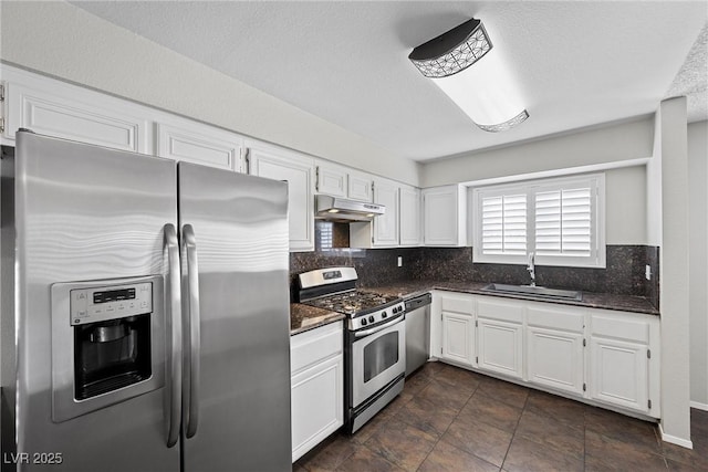 kitchen featuring under cabinet range hood, stainless steel appliances, a sink, white cabinets, and decorative backsplash