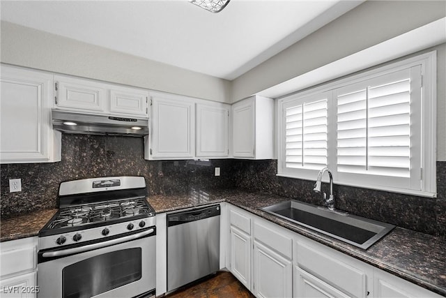 kitchen featuring under cabinet range hood, stainless steel appliances, a sink, white cabinets, and decorative backsplash