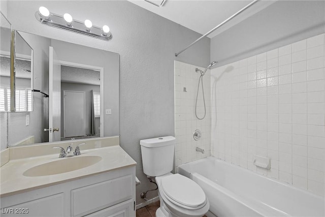 full bathroom featuring tub / shower combination, a textured wall, vanity, and toilet