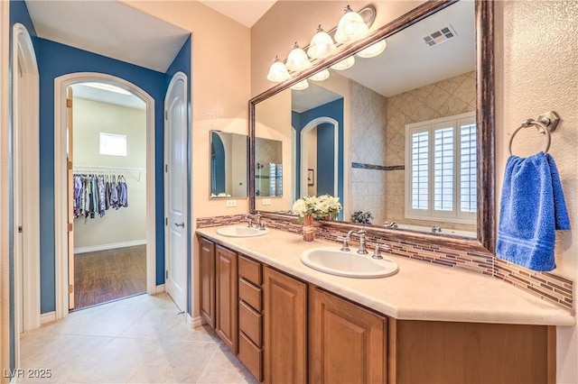 full bath featuring double vanity, visible vents, a sink, and tile patterned floors