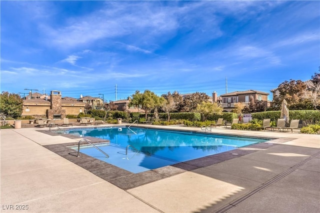 outdoor pool featuring a patio area and fence