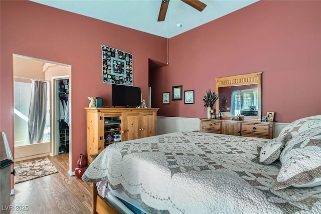 bedroom with a closet, ceiling fan, a spacious closet, and wood finished floors