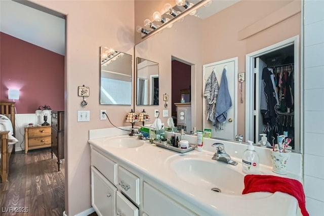 bathroom with double vanity, wood finished floors, ensuite bath, and a sink