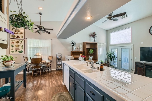 kitchen with dark wood finished floors, dishwasher, tile countertops, french doors, and a sink