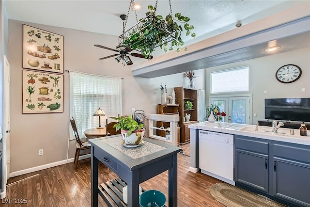 kitchen with dishwasher, tile countertops, dark wood finished floors, and blue cabinets