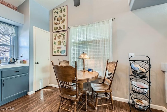 dining room with lofted ceiling, baseboards, and dark wood finished floors