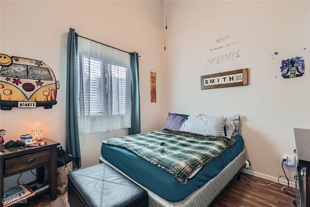 bedroom with baseboards and wood finished floors