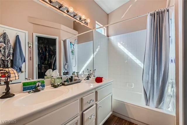 full bathroom with wood finished floors, a sink, shower / bathtub combination with curtain, and double vanity