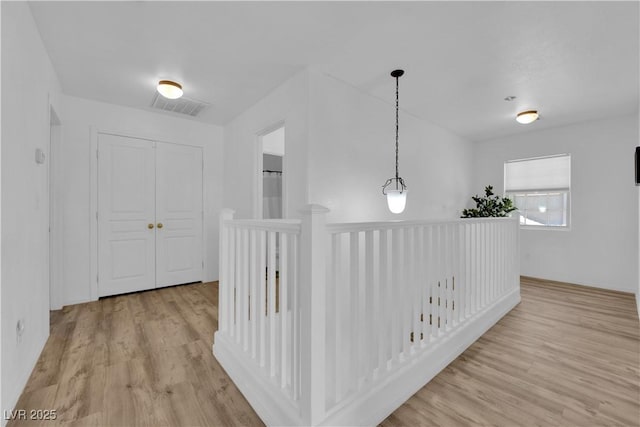 hallway featuring visible vents and light wood-style floors