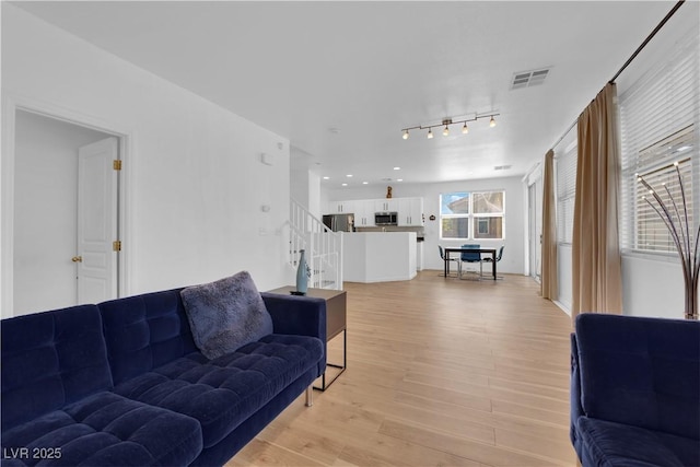 living room with light wood-style flooring, stairs, visible vents, and recessed lighting