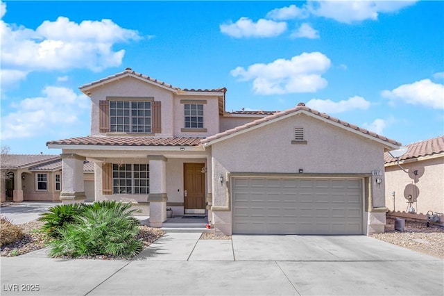 mediterranean / spanish house with an attached garage, covered porch, concrete driveway, and stucco siding