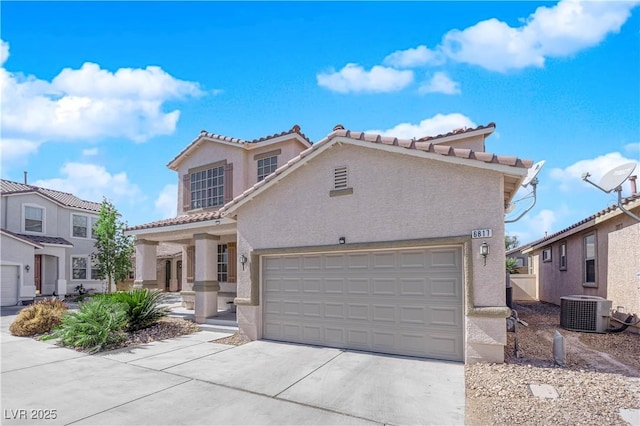 mediterranean / spanish-style home featuring a garage, driveway, central AC unit, and stucco siding