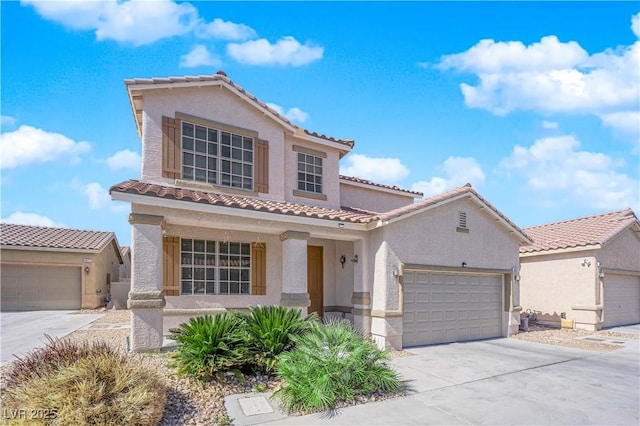 mediterranean / spanish home with driveway, a tiled roof, an attached garage, and stucco siding