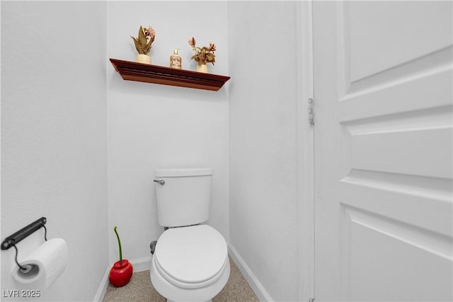 bathroom with toilet and baseboards