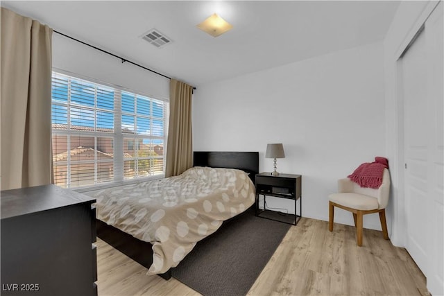 bedroom with light wood finished floors and visible vents