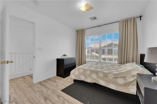 bedroom featuring visible vents, baseboards, and wood finished floors