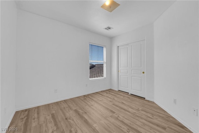 unfurnished bedroom featuring light wood finished floors, visible vents, and baseboards