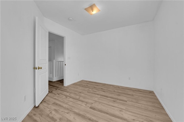 empty room with light wood-style flooring and baseboards