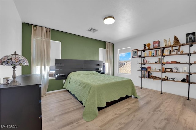 bedroom with visible vents and wood finished floors