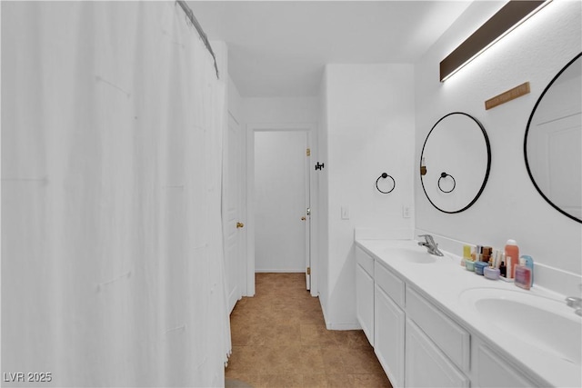 bathroom with a sink, baseboards, and double vanity