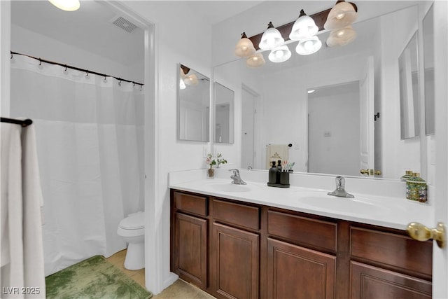 full bath featuring toilet, double vanity, a sink, and visible vents