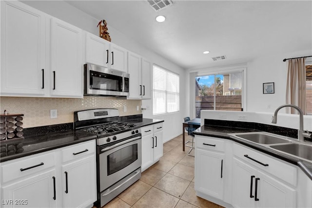 kitchen featuring appliances with stainless steel finishes, a sink, visible vents, and decorative backsplash